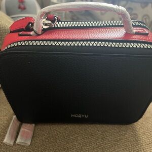 Red and black crossbody with double-sided zipper.